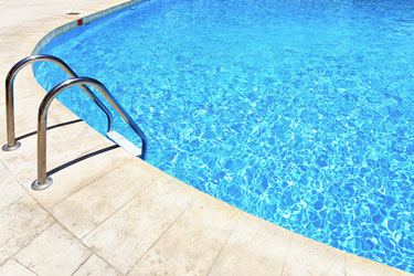 A ladder leading into a pool with clear blue water.